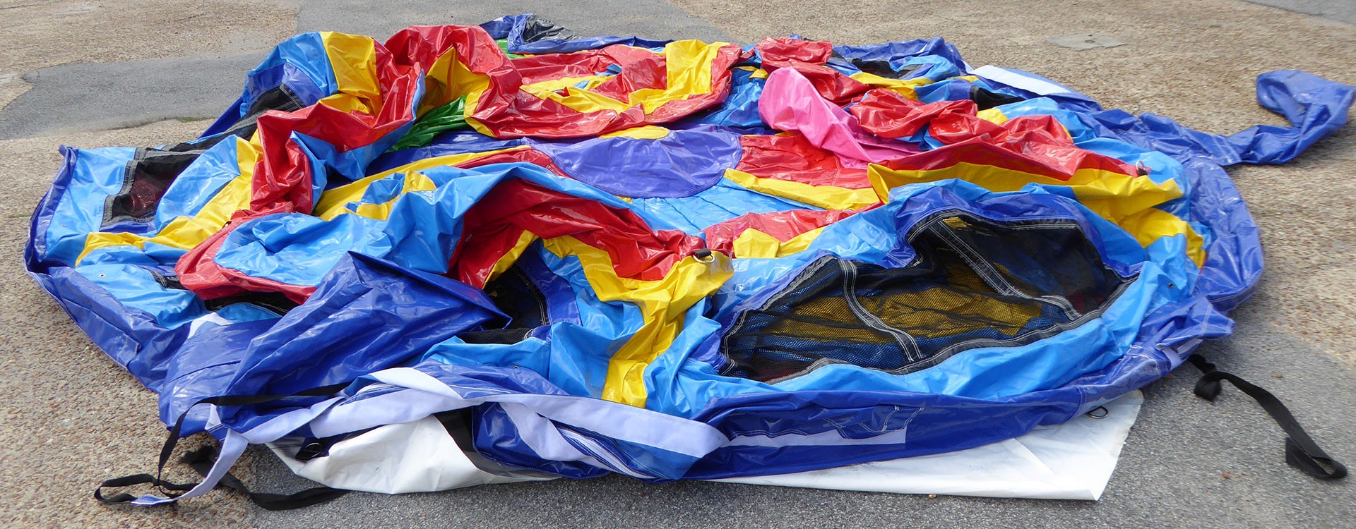 Un employé décharge une structure gonflable pliée depuis une camionnette ouverte dans une allée